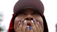 Seorang penonton dengan kuku yang dicat menyaksikan upacara pembukaan Olimpiade Musim Panas 2024. AP/Steph Chambers