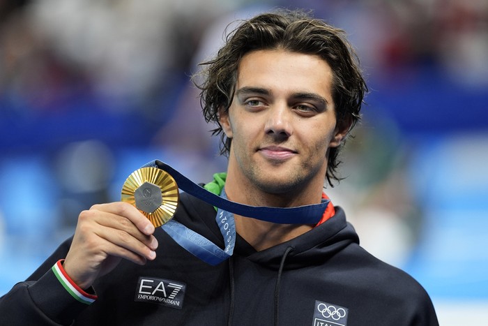Gold medalist Thomas Ceccon, of Italy, poses on the podium after the mens 100-meter backstroke final at the 2024 Summer Olympics, Monday, July 29, 2024, in Nanterre, France. (AP Photo/Martin Meissner)