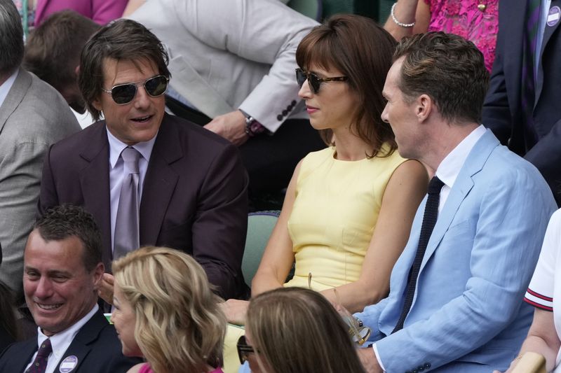Tom Cruise, left, speaks to Benedict Cumberbatch, right, and Shoppe Hunter in the Royal Box ahead of the men's singles final match at the Wimbledon tennis championships in London, Sunday, July 14, 2024. (AP Photo/Mosa'ab Elshamy)