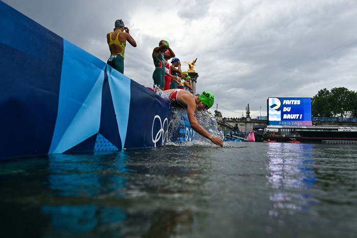 Paris 2024 Olympics - Triathlon - Womens Individual - Alexander III Bridge, Paris, France - July 31, 2024. Zsanett Kuttor-Bragmayer of Hungary splashes water on her face from the river Seine before the start of the race. Martin Bureau/Pool via REUTERS