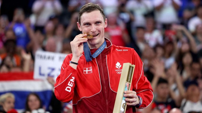 PARIS, FRANCE - AUGUST 05: Gold Medallist, Viktor Axelsen of Team Denmark bites his medal on the podium during the the Badminton Mens Singles medal ceremony after the Badminton Mens Singles Gold Medal match on day ten of the Olympic Games Paris 2024 at Porte de La Chapelle Arena on August 05, 2024 in Paris, France. (Photo by Alex Pantling/Getty Images)
