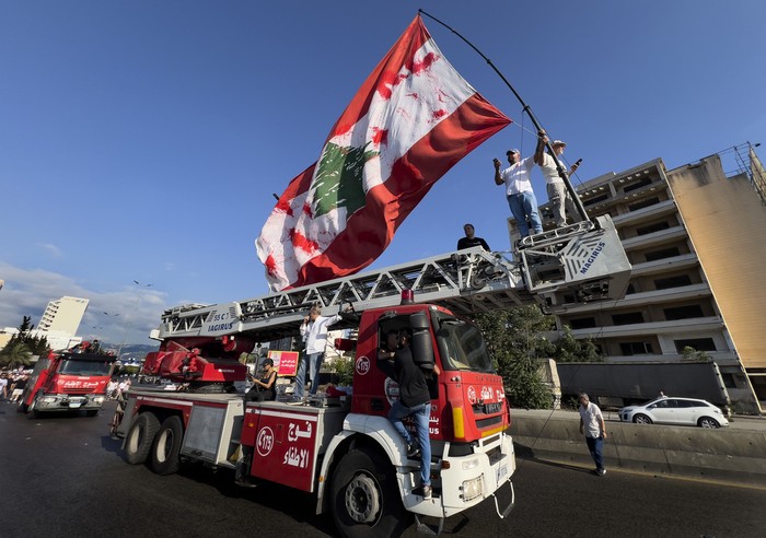Lebanese army soldiers stand guard in front of grain silos that were gutted in the deadly 2020 Beirut port explosion, as they watch mourners mark the fourth anniversary of the blast, in Beirut, Lebanon, Sunday, Aug. 4, 2024. (AP Photo/Hussein Malla)