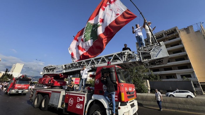 Lebanese army soldiers stand guard in front of grain silos that were gutted in the deadly 2020 Beirut port explosion, as they watch mourners mark the fourth anniversary of the blast, in Beirut, Lebanon, Sunday, Aug. 4, 2024. (AP Photo/Hussein Malla)