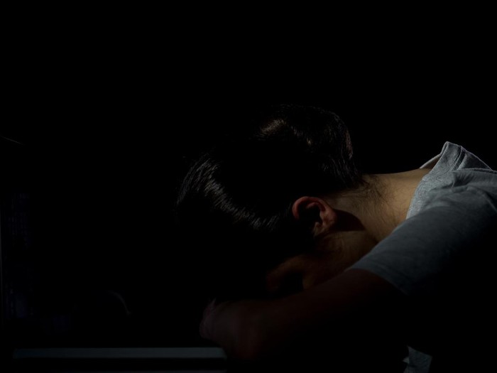 Tired woman lying on laptop, desperate of overwork, exhausted night shift