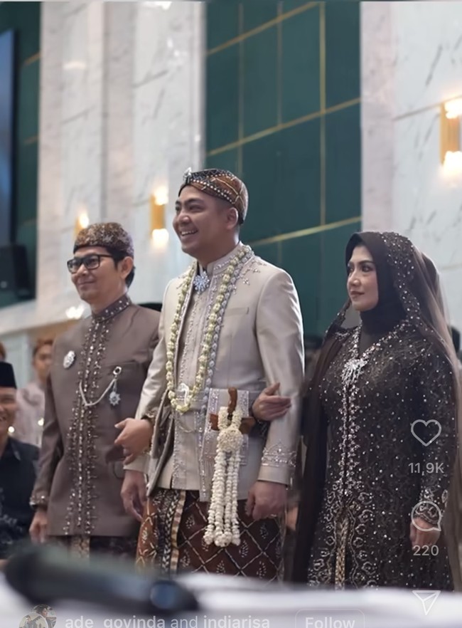 Sementara Ade tampil gagah mengenakan baju pengantin Sunda berwarna coklat, senada dengan Indi. Ia juga melengkapi penampilannya dengan blangkon dan kalung dari roncean melati. Ade juga membawa keris di saku kiri pakaiannya. Foto: Instagram/@ade_govinda