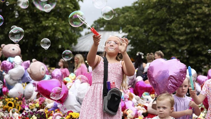 Tributes are seen outside the Town Hall during a vigil to remember the victims of the stabbing attack last Monday in Southport, England, Monday, Aug. 5, 2024. Violence and unrest erupted in cities and towns across Britain, ostensibly in protest of last week's stabbing. (AP Photo/Darren Staples)