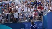 Penonton disemprot air saat cuaca sangat panas di pertandingan voli pantai antara Amerika Serikat dan Maroko di Olimpiade Musim Panas 2024. AP/Robert F. Bukaty