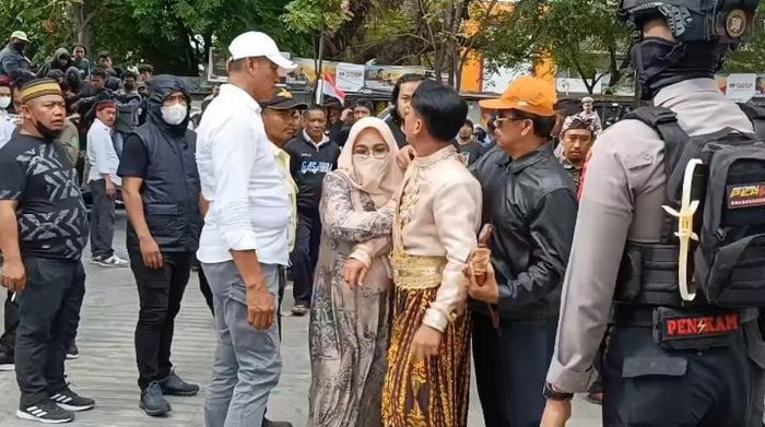 Momen pengantin turun dari mobil gegara akses jalan ditutup mahasiswa yang demo di depan Kampus I UIN Alauddin Makassar.