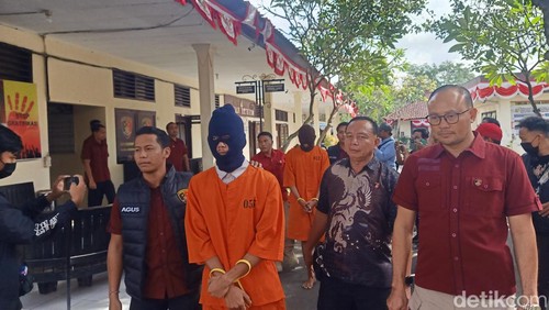 Tersangka pemerkosa anak tiri saat digiring polisi di Mapolres Jembrana, Kabupaten Jembrana, Selasa (6/8/2024). (I Putu Adi Budiastrawan/detikBali).