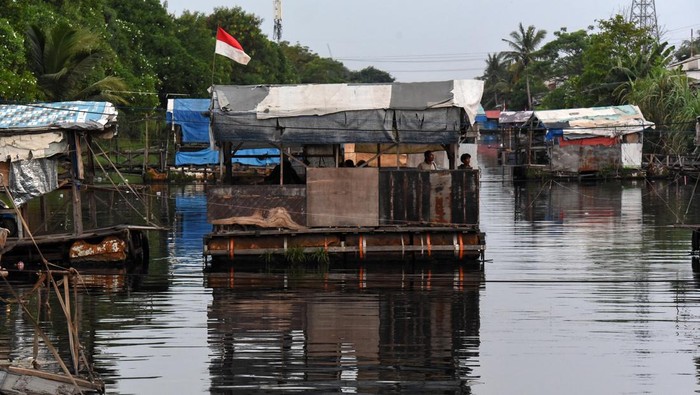 Pengendara motor berjalan keluar usai menumpang perahu eretan di Kali Rawa Malang, Cilincing, Jakarta Utara, Senin (5/8/2024). Warga menggunakan jasa perahu eretan sebagai transportasi alternatif untuk mempersingkat jarak tempuh dengan membayar Rp1.000 hingga Rp2.000 untuk sekali menyeberang. ANTARA FOTO/Indrianto Eko Suwarso/nz