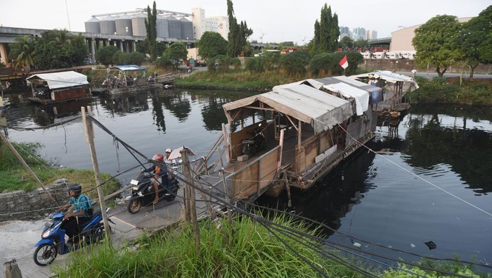 Pengendara motor berjalan keluar usai menumpang perahu eretan di Kali Rawa Malang, Cilincing, Jakarta Utara, Senin (5/8/2024). Warga menggunakan jasa perahu eretan sebagai transportasi alternatif untuk mempersingkat jarak tempuh dengan membayar Rp1.000 hingga Rp2.000 untuk sekali menyeberang. ANTARA FOTO/Indrianto Eko Suwarso/nz