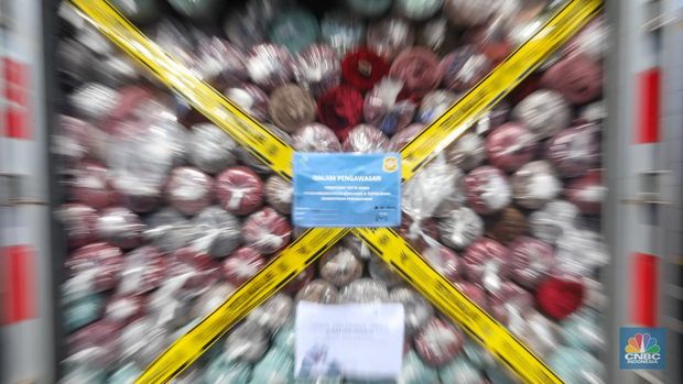 Petugas Bea Cukai berjaga disamping pakain bekas (balpres) di Tempat Penimbunan Pabean (TPP) Bea dan Cukai, Cikarang, Kabupaten Bekasi, Jawa Barat, Selasa (6/8/2024). (CNBC Indonesia/Faisal Rahman)