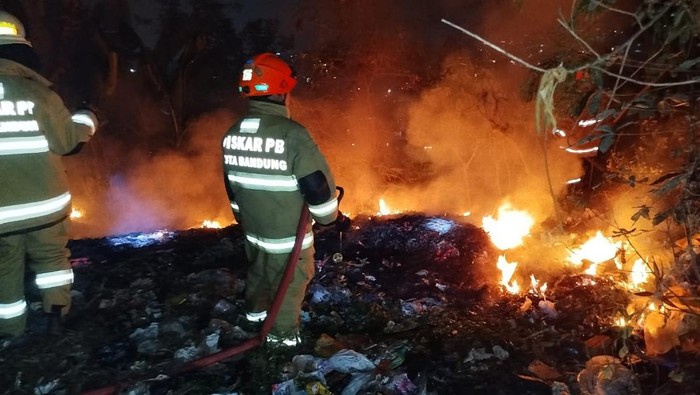 Petugas pemadam kebakaran berupaya memadamkan api di eks TPA Cicabe Bandung, Selasa (6/8/2024).