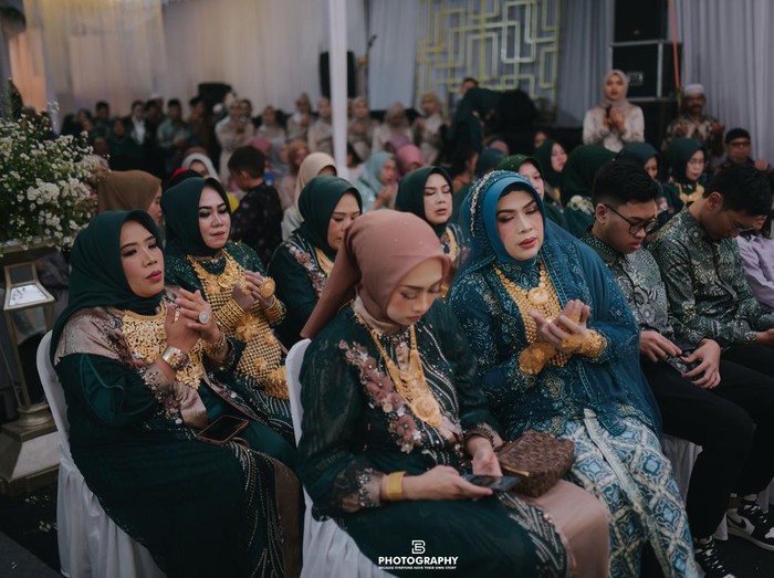 Resepsi pernikahan ini mendadak jadi sorotan karena tamu yang hadir memakai emas berukuran besar bak toko emas berjalan. Acara resepsi itu langsung viral di media sosial.