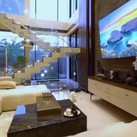 Unsur kayu mendominasi eksterior hingga interior rumah. Pintu depan saja terbuat dari kayu merbau Papua yang kokoh. Di ruang keluarga, elemen kayu menciptakan atmosfer yang hangat. (Foto: YouTube/Trans7 Official)