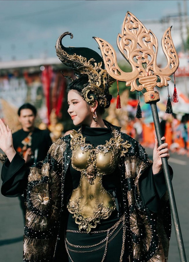 Breastplate emas diaplikasikan pada bagian dada hingga torso, kontras dengan pakaian hitam yang dikenakannya. Foto: Instagram/@tiaraandini @jemberfashioncarnaval