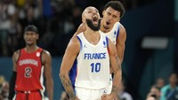 Pemain Prancis Evan Fournier (tengah) merayakan gol bersama pemain Prancis Victor Wembanyama (kanan) saat pemain Kanada Shai Gilgeous-Alexander menyaksikan pertandingan bola basket putra di Olimpiade Musim Panas 2024, Paris, Prancis, Selasa (6/8/2024). (AP Photo/Michael Conroy)  