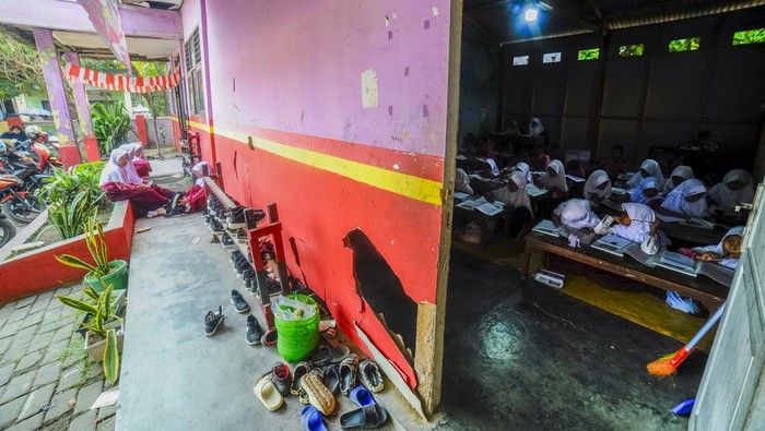 Sejumlah siswa kelas empat mengikuti kegiatan belajar mengajar dengan lesehan di ruang kantin SD Negeri Suci, Kota Serang, Banten, Rabu (7/8/2024). Pihak sekolah menyebutkan, dalam sewindu terakhir sebanyak tujuh ruang kelas rusak bagian dinding, atap dan lantai sehingga sekolah terpaksa menggunakan salah satu ruangan kantin menjadi ruang belajar siswa. ANTARA FOTO/Muhammad Bagus Khoirunas/rwa.