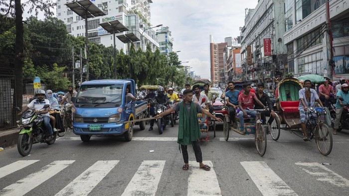 A volunteer manages road traffic in Dhaka, Bangladesh, Tuesday, Aug. 6, 2024. (AP Photo/Rajib Dhar)