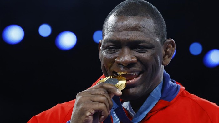Paris 2024 Olympics - Wrestling - Mens Greco-Roman 130kg Victory Ceremony - Champ-de-Mars Arena, Paris, France - August 06, 2024. Gold medallist Mijain Lopez Nunez of Cuba bites his medal. REUTERS/Kim Kyung-Hoon