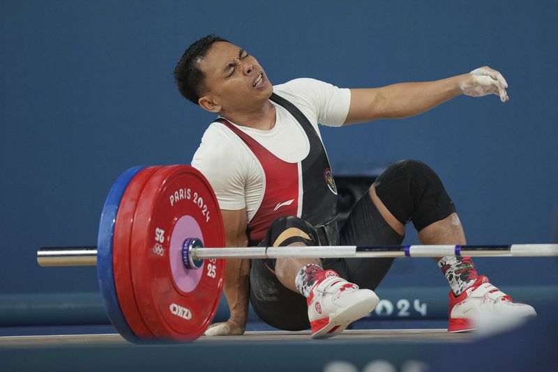 Eko Irawan of Indonesia reacts after failing to lift during the men's 61kg weightlifting event at the 2024 Summer Olympics, Wednesday, Aug. 7, 2024, in Paris, France. (AP Photo/Kin Cheung)