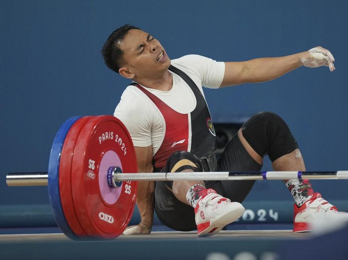 Eko Irawan of Indonesia reacts after failing to lift during the mens 61kg weightlifting event at the 2024 Summer Olympics, Wednesday, Aug. 7, 2024, in Paris, France. (AP Photo/Kin Cheung)