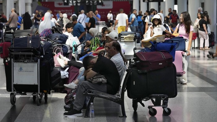 Passengers whose flights were cancelled, wait at the departure terminal ground of Rafik Hariri International Airport, in Beirut, Lebanon, Monday, Monday, Aug. 5, 2024. Turkey and Japan became the latest countries to urge their citizens to leave Lebanon amid rising tensions with Israel following last week's airstrike in Beirut that killed a top Hezbollah military commander. Fears of an escalation in the simmering conflict between Hezbollah and Israel have prompted some airlines to cancel flights to Lebanon. (AP Photo/Hussein Malla)