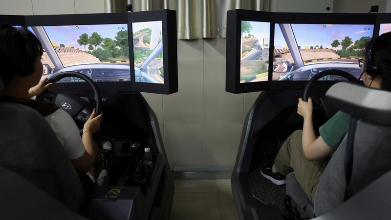 A driving instructor guides a student practising on a virtual reality (VR) car driving simulator at Eastern Pioneer Driving School in Beijing, China July 23, 2024. REUTERS/Florence Lo