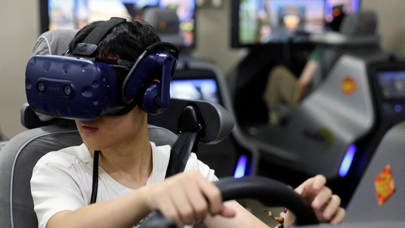 A driving instructor guides a student practising on a virtual reality (VR) car driving simulator at Eastern Pioneer Driving School in Beijing, China July 23, 2024. REUTERS/Florence Lo