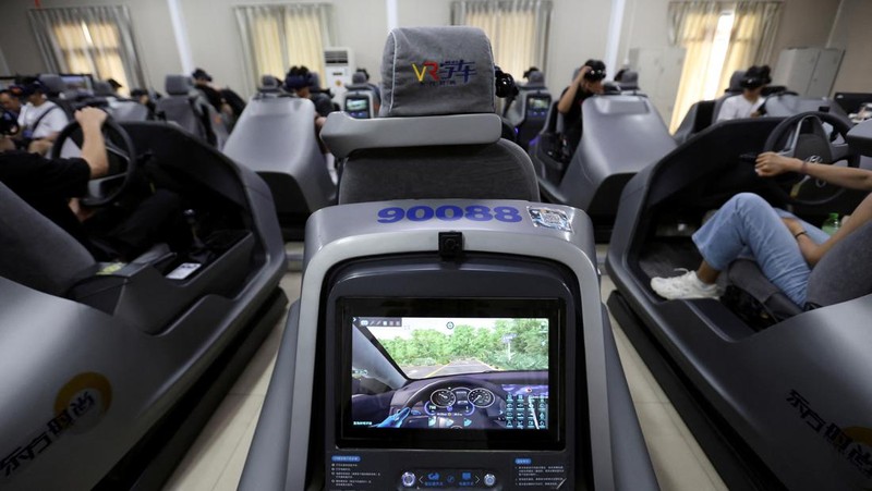 A driving instructor guides a student practising on a virtual reality (VR) car driving simulator at Eastern Pioneer Driving School in Beijing, China July 23, 2024. REUTERS/Florence Lo