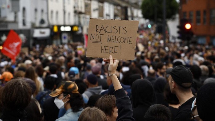 A protester holds a placard reading 