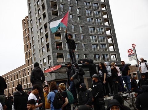 A protester waves a Palestinian flag during a counter demonstration against an anti-immigration protest called by far-right activists in the Walthamstow suburb of London on August 7, 2024. Thousands of anti-racism protesters took to the streets in several English cities on Wednesday to oppose violent far-right demonstrations that have gripped the country in recent days. (Photo by BENJAMIN CREMEL / AFP)