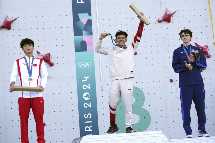 Gold medallist Veddriq Leonardo of Indonesia, center, poses on the podium with silver medallist Wu Peng of China, left, and bronze medallist Sam Watson of the United States after the mens speed final during the sport climbing competition at the 2024 Summer Olympics, Thursday, Aug. 8, 2024, in Le Bourget, France. (AP Photo/Tsvangirayi Mukwazhi)