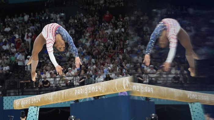 Lompatan Memukau Atlet Olimpiade Paris 2024 Jordan Chiles, of the United States, performs on the balance beam and is reflected on an information screen during the women's artistic gymnastics team finals round at Bercy Arena at the 2024 Summer Olympics, Tuesday, July 30, 2024, in Paris, France. (AP Photo/Charlie Riedel)