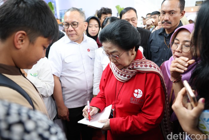 Megawati Soekarnoputri menuliskan pesan ke seorang pelajar di pameran. (Rizky Adha Mahendra/detikcom)