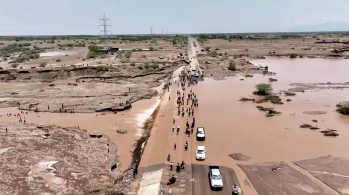 Penampakan Banjir Bandang di Yasman yang Tewaskan 45 Orang Drone footage shows people walking surrounded by flood waters, in Hodeidah Province, Yemen, August 7, 2024, in this screengrab taken from a handout video. Al Masirah TV/REUTERS TV via REUTERS THIS IMAGE HAS BEEN SUPPLIED BY A THIRD PARTY