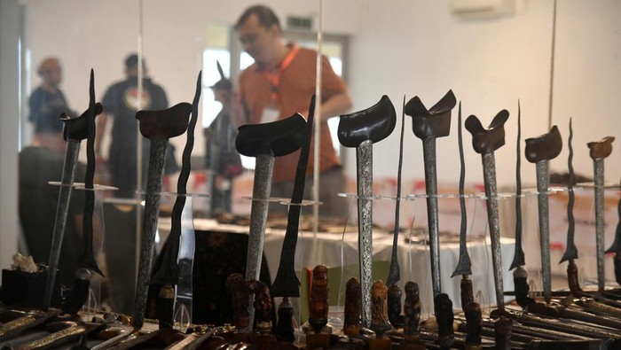 Pengunjung memegang senjata golok saat pameran Pesona Pusaka Nusantara 2024  di Bogor Creative Center, Kota Bogor, Jawa Barat, Kamis (8/8/2024). Pesona Pusaka Nusantara 2024 diselenggarakan komunitas Pelestari Golok Pedang Nusantara dengan kegiatan pameran pusaka, edukasi budaya, seni kreasi silat dan musik tradisional Sunda untuk mengenalkan dan melestarikan warisan budaya bangsa kepada generasi muda. ANTARA FOTO/Arif Firmansyah/foc.