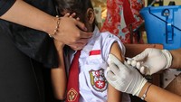 Seorang siswa menutup matanya saat disuntikkan vaksin imunisasi Measles Rubella (MR) pada kegiatan bulan imunisasi anak sekolah (BIAS) di SD Negeri Sawah Besar 2, Semarang, Jawa Tengah, Kamis (8/8/2024).