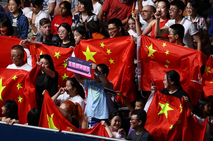 Paris 2024 Olympics - Table Tennis - Mixed Doubles Gold Medal Match - South Paris Arena 4, Paris, France - July 30, 2024. Fans react in the stands as they display the flag of China during the match between Chuqin Wang of China and Yingsha Sun of China against Jong Sik Ri of North Korea and Kum Yong Kim of North Korea. REUTERS/Stephanie Lecocq