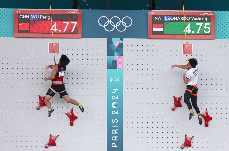 PARIS, FRANCE - AUGUST 08: Veddriq Leonardo of Team Indonesia finishes ahead of Wu Peng of Team People's Republic of China to win the Gold medal during the Men's Speed - Big Final on day thirteen of the Olympic Games Paris 2024 at Le Bourget Sport Climbing Venue on August 08, 2024 in Paris, France. (Photo by Michael Reaves/Getty Images)