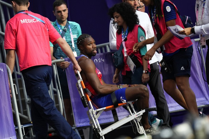 PARIS, FRANCE - AUGUST 08: Bronze medalist Noah Lyles of Team United States is taken off from the track with a wheelchair after competing in the Men's 200m Final on day thirteen of the Olympic Games Paris 2024 at Stade de France on August 08, 2024 in Paris, France. (Photo by Christian Petersen/Getty Images)