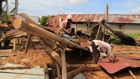 Sejumlah pekerja melepas kepingan atap gudang yang rusak akibat angin puting beliung di Jalan Tabrani Ahmad, Pontianak, Kalimantan Barat, Jumat (9/8/2024). 