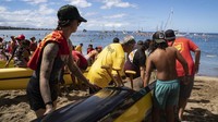 Para peselancar, pendayung kano, dan pengendara perahu dari Maui turun ke laut lepas Lahaina pada Kamis untuk mengenang 102 orang yang tewas saat kebakaran hutan paling mematikan di negara itu satu tahun lalu.  