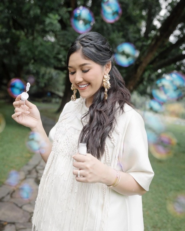 Inilah penampilan Erina saat pemotretan khusus untuk kehamilannya. Erina memilih mengenakan blouse berwarna krem yang dipermanis dengan aksesori tambahan, seperti gelang, cincin, dan sepasang anting emas yang cukup besar yang menjuntai dari kedua telinganya. Rambutnya diikat satu dan dicatok bergelombang dengan bagian atas yang sedikit. (Foto: Instagram/@erinagudono)
