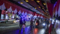 Sejumlah warga berjalan di lorong merah putih bertema Nusantara Baru Indonesia Maju di Kampung Cibahong, Desa Sukamenak, Kabupaten Tasikmalaya, Jawa Barat, Kamis (8/8/2024).