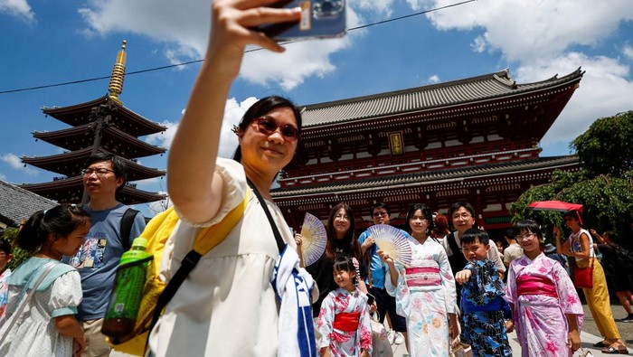 Mengunjungi Sensoji Temple, Kuil Paling Ramai di Tokyo Visitors wearing kimonos take a selfie as they visit Sensoji temple in Tokyo, Japan, August 9, 2024. REUTERS/Willy Kurniawan