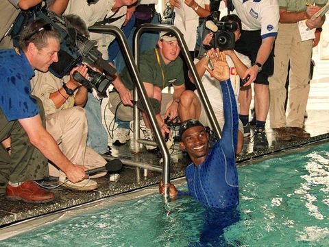 Overnight swimming sensation, Eric Moussambani from Equatorial Guinea waves to a pool full of onlookers after he completes his 50m demonstration at the Cook & Philip Pool in Sydney, Australia, Wednesday, September 20, 2000. Moussambani, one of the four-person swim team from Equatorial Guinea was given the Speedo Fast.Skin bodysuit to test in the pool Wednesday. (AP Photo/Rob Griffith)