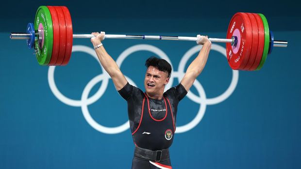 PARIS, FRANCE - AUGUST 08: Rizki Juniansyah of Team Indonesia completes an Olympic Record of 199kg in the clean and jerk during the Weightlifting Men's 73kg on day thirteen of the Olympic Games Paris 2024 at South Paris Arena on August 08, 2024 in Paris, France. (Photo by Matthew Stockman/Getty Images)