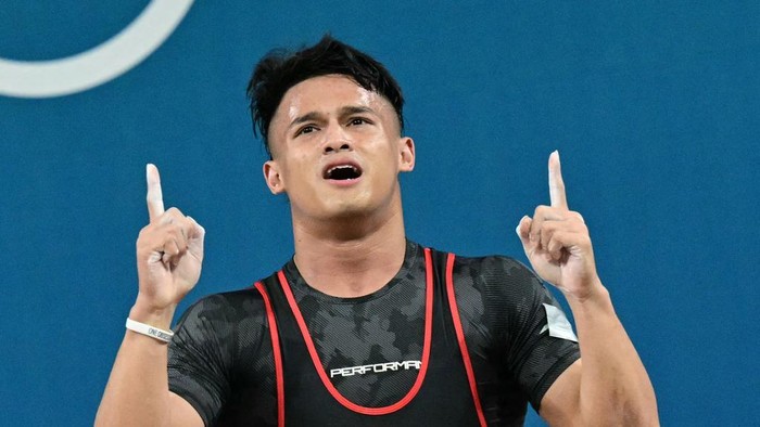 Indonesias Rizki Juniansyah celebrates after beating the record in the mens -73kg weightlifting event during the Paris 2024 Olympic Games at the South Paris Arena in Paris, on August 8, 2024. (Photo by Miguel MEDINA / AFP)