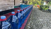 Rumah warga dikelilingi galon berisi air dengan pewarna. Foto: Ikbal Selamet/detikJabar